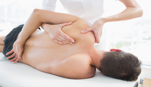 Office worker being massaged at Cambridge Massage Clinic for neck and shoulder injury.