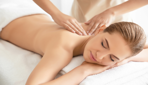 Neck and shoulder massage at Cambridge Massage Clinic with lady lying on white comfortable towels.