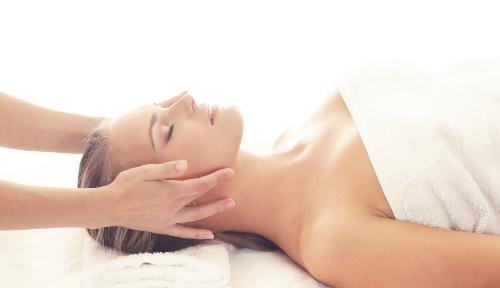 Postural massage at Cambridge Massage Clinic with client relaxing on white comfortable towels.